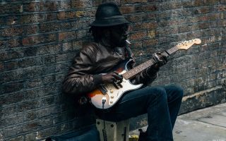 музыкант играет на электро гитаре на улице