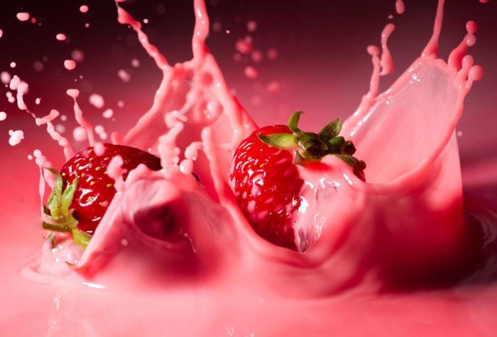 Картинка ягоды клубники падают в молочный коктейль