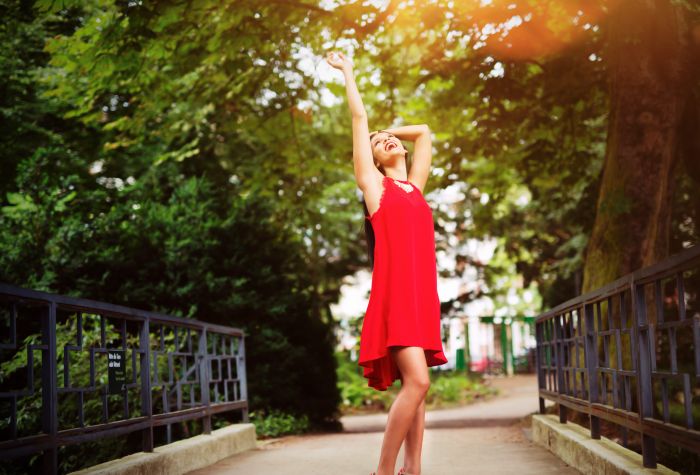 Картинка девушка в красном платье с улыбкой на мосту