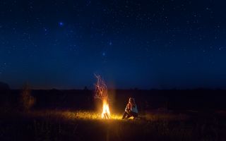 девушка ночью у костра на природе под звездным небом