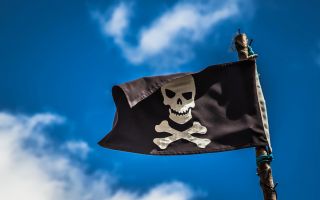 пиратский флаг развивается на фоне неба